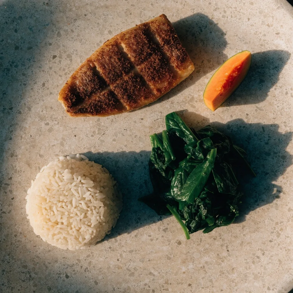 Piring makan seimbang di atas meja batu dengan porsi nasi, sayur, dan lauk